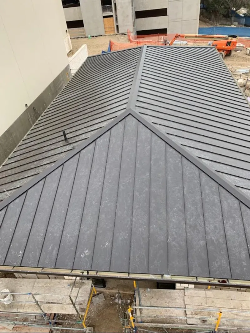 Commercial metal roof construction with crane equipment in Flowood